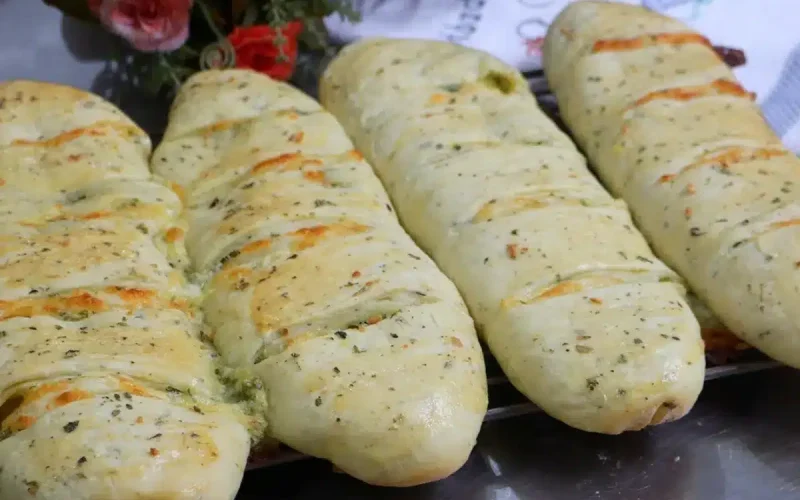 Delícia de pão de alho com queijo cremoso e temperos, perfeito para forno ou churrasqueira